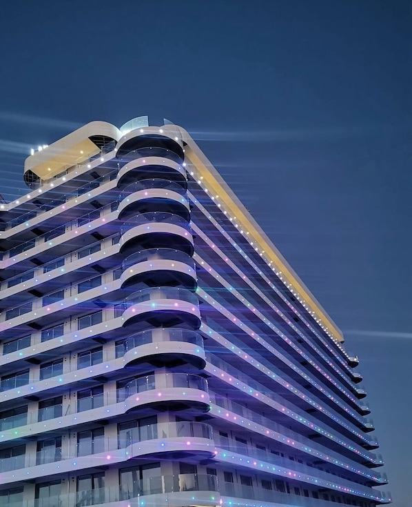 Un hôtel à plusieurs étages, doté d’une façade incurvée et de balcons.