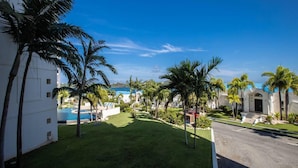 Ein Resort mit Swimmingpool, Palmen und Blick auf den Ozean.