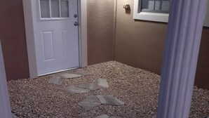 A room with a door, a window, and a stone pathway. - We are the coolest hosts on the planet! You will love it here!  (Holiday)
