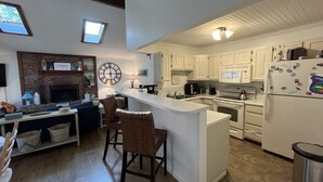 A modern kitchen with white cabinets, a built-in oven, and a refrigerator with magnets.