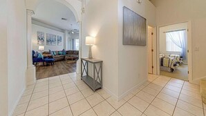 A spacious living area with a sofa set, a console table, and a painting on the wall. - Gorgeous 4 Bedroom, Disney And South Facing Pool (Davenport)