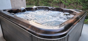 A hot tub with multiple jets, surrounded by a wooden deck and greenery. - 2 bedrooms with private bathroom and kitchen in shared villa with  swimming pool (Saint-Raphaël)