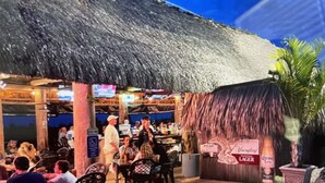 An outdoor restaurant with thatched roofs and outdoor seating. -  Starfish Cottage - Summer fun.  Sleeps 4 -boating fishing and Lobster 🦞 season. (Summerland Key)