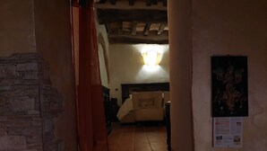 Eine enge Treppe führt zu einem Schlafzimmer mit einem Bett, einem Nachttisch und einer Wandleuchte.