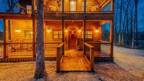 A two-story log cabin with a wooden deck and a covered front porch. - Driftaway Lodge | Luxury Broken Bow Cabin with Game Room, Hot Tub & Fire Pit (Broken Bow)