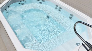 Un jacuzzi con una escalera metálica y burbujas en el agua.