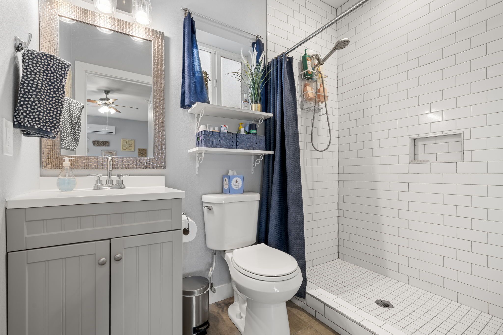 Et badeværelse med toilet, håndvask og bruser.