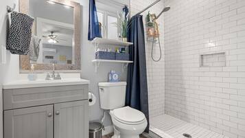 Et badeværelse med toilet, håndvask og bruser.