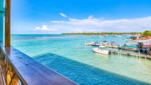Una marina con barcos amarrados, agua turquesa cristalina y un muelle de madera.