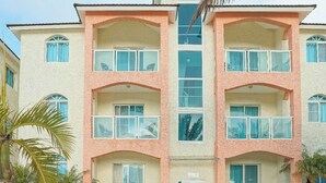 Un immeuble à plusieurs étages doté d’une entrée centrale, de balcons et d’une façade symétrique.