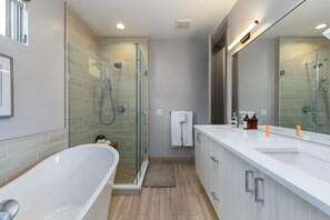 Een bad/douchecombinatie, een haardroger, handdoeken, shampoo