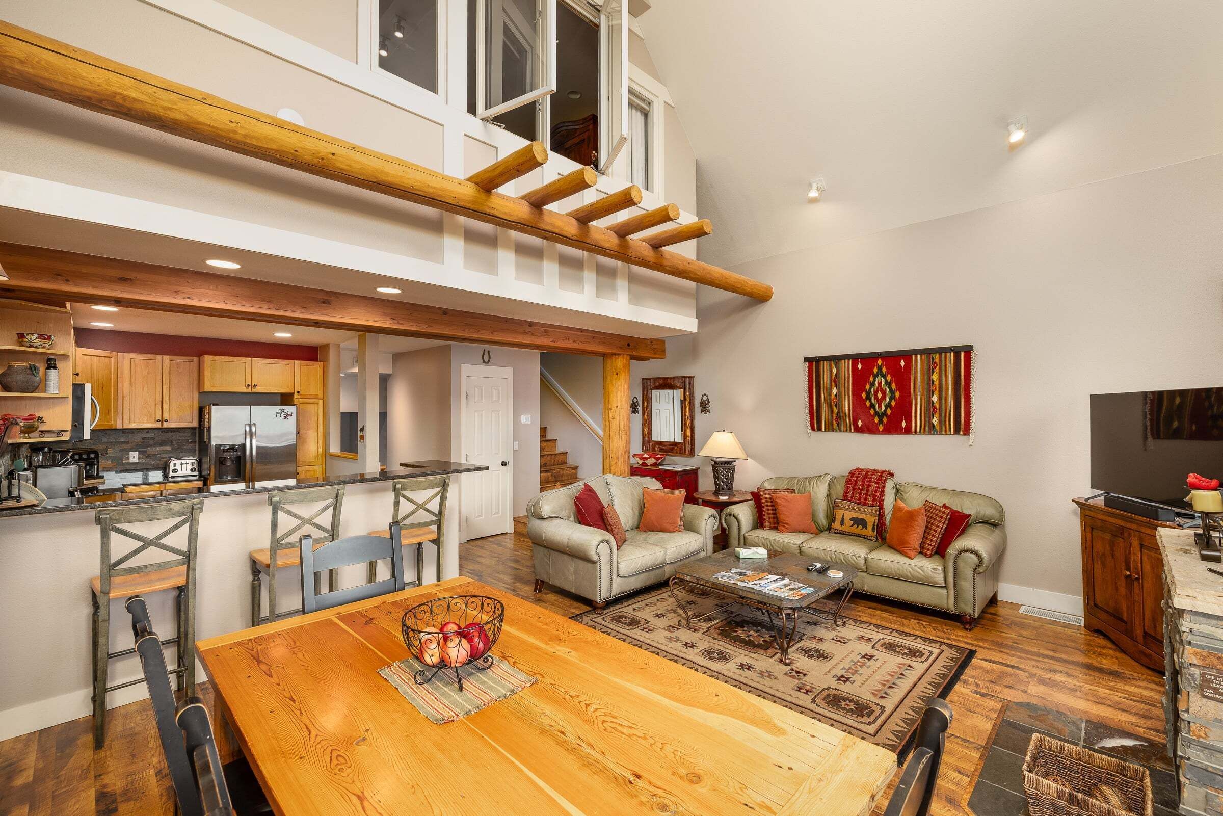 A spacious living area with a dining table, sofas, and a kitchen in the background.