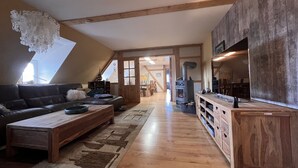Un espacio habitable tipo loft con piso de madera, un sofá, una mesa de centro y una chimenea.