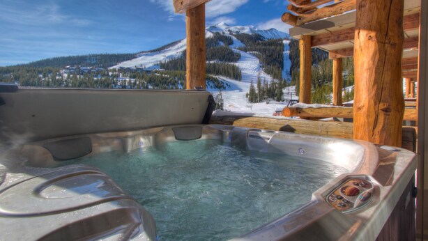 Un bain à remous offrant une vue dégagée sur un paysage montagneux enneigé.