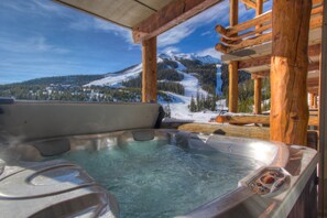 Un jacuzzi con vistas despejadas a un paisaje montañoso nevado.