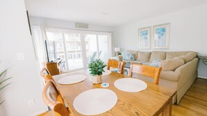 Un coin repas avec une table en bois, quatre chaises et une plante servant de décoration centrale.