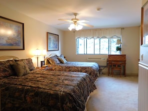 Cozy retreat with a large bed, desk, and window with curtains.