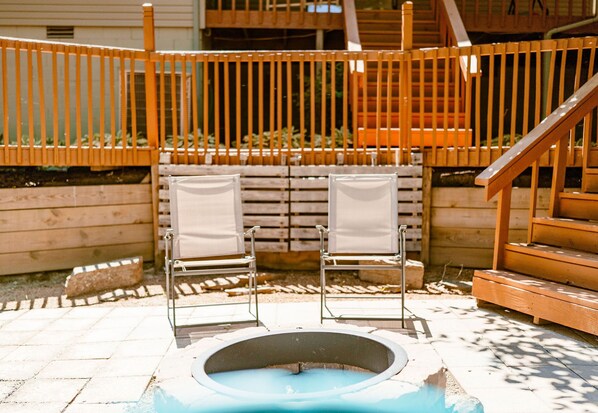 Relax in the hot tub surrounded by lush surroundings and comfortable lounge chairs.