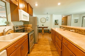 Enjoy cooking in this well-equipped kitchen with a double sink, stove, and refrigerator.