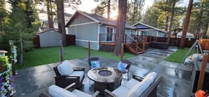 A patio with outdoor furniture, a fire pit, and a wooden deck leading to a house. - Spa Central AC-Heat  Fenced Yard EVC Pup friendly (Big Bear Lake)