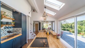 Una cocina moderna con tragaluces, suelo de madera y vistas al exterior.