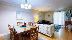 A dining area with a table and chairs, a sofa, and a lamp. - Cozy Winter Escape (Laconia)