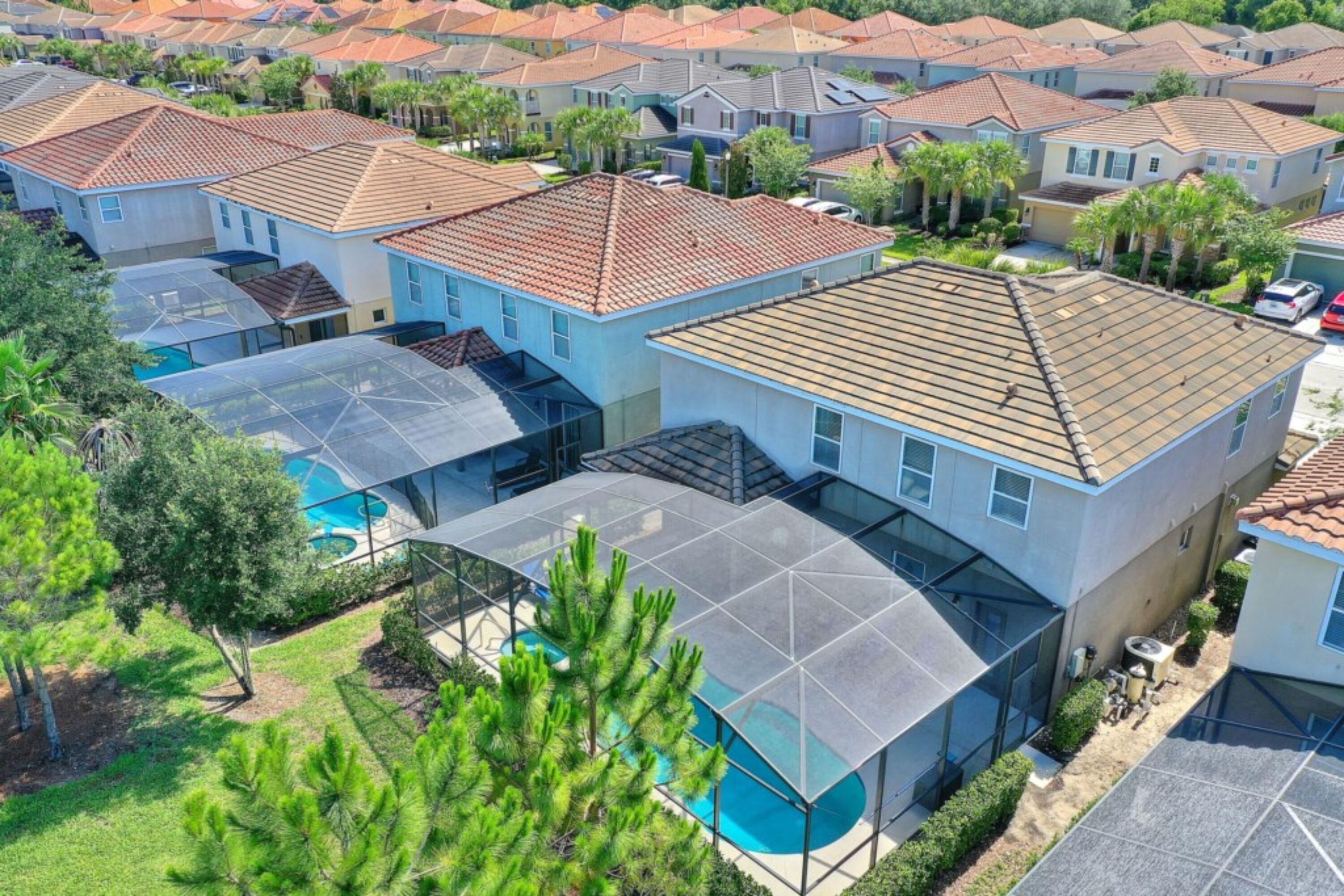 A residential area with modern houses, a swimming pool, and a covered outdoor area.