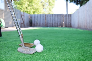 A golf putting green with a putter and two golf balls. - Duplex with Backyard and Putting Green (Beaverton)