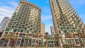 A modern hotel with a curved facade, multiple floors, and a glass exterior.