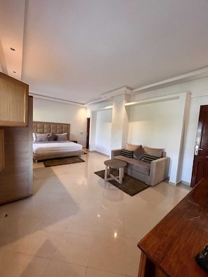 Relax in a stylish space with a large bed, sofa, and desk.