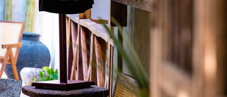 Un mannequin portant une robe à motifs floraux, placé dans un décor extérieur avec une structure en bois et un cactus en arrière-plan.