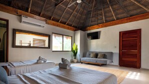 A hotel room with two beds, a sofa, a ceiling fan, a large window, and a door. - Alma de Zorro (Bacalar)