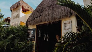 A thatched-roof building with a sign reading "Alma de Loro Hotel & Bar." - Alma de Zorro (Bacalar)