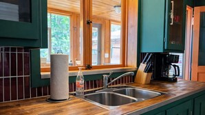A kitchen with wooden countertops, a stainless steel sink, and green cabinets. - Gresham Shores - Woodies Perch - PET FRIENDLY (Arbor Vitae)