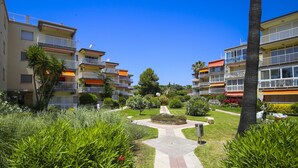 Une cour intérieure avec un chemin central, entourée d’immeubles à plusieurs étages dotés de balcons et d’un jardin bien entretenu.