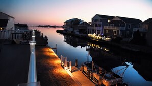 A waterfront property with a dock, a boat, and houses with balconies.