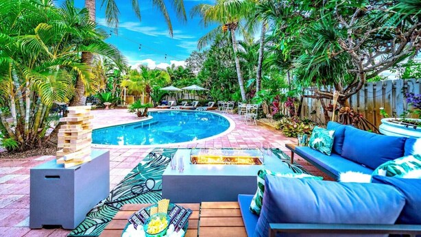 A pool area with a hot tub, lounge chairs, and a wooden deck. - NEW! 5 BED/5 MIN TO BEACH/HTD POOL/HOT TUB/BAR (Oakland Park)