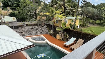 Relax in a serene backyard with a swimming pool, hot tub, and comfortable lounge chairs.