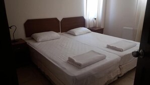 A double bed with white linens, two pillows, and a folded towel on the side. - DM Residence Butik Otel (Datça)