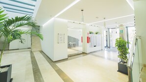A modern lobby with a staircase, a reception desk, and a plant. - Cubo's Sea View Pacifico Street & Free Parking / free wifi / air conditioning (Málaga)