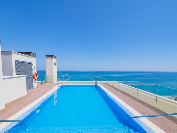 A swimming pool with a clear view of the ocean.