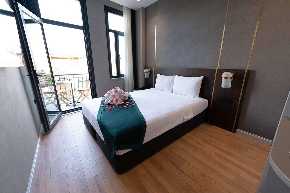 Ein modernes Hotelzimmer mit einem großen Bett, einem Balkon und Blick ins Freie.
