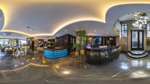 A modern hotel lobby with a reception desk, seating area, and a staircase. - Costera Hotel (Istanbul)