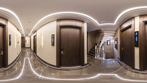 A hotel corridor with wooden doors, numbered room signs, and a marble floor. - Costera Hotel (Istanbul)