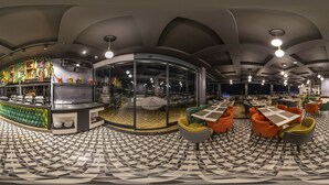 A modern restaurant with a curved glass wall, a buffet area, and a seating area with colorful chairs. - Costera Hotel (Istanbul)