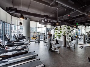 Ein modernes Fitnessstudio mit Laufbändern, Kraftgeräten und Gymbällen.