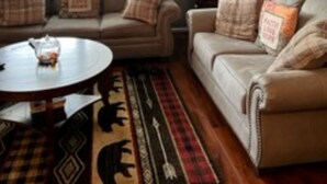 Una sala de estar con dos sofás, una mesa de centro y una alfombra.