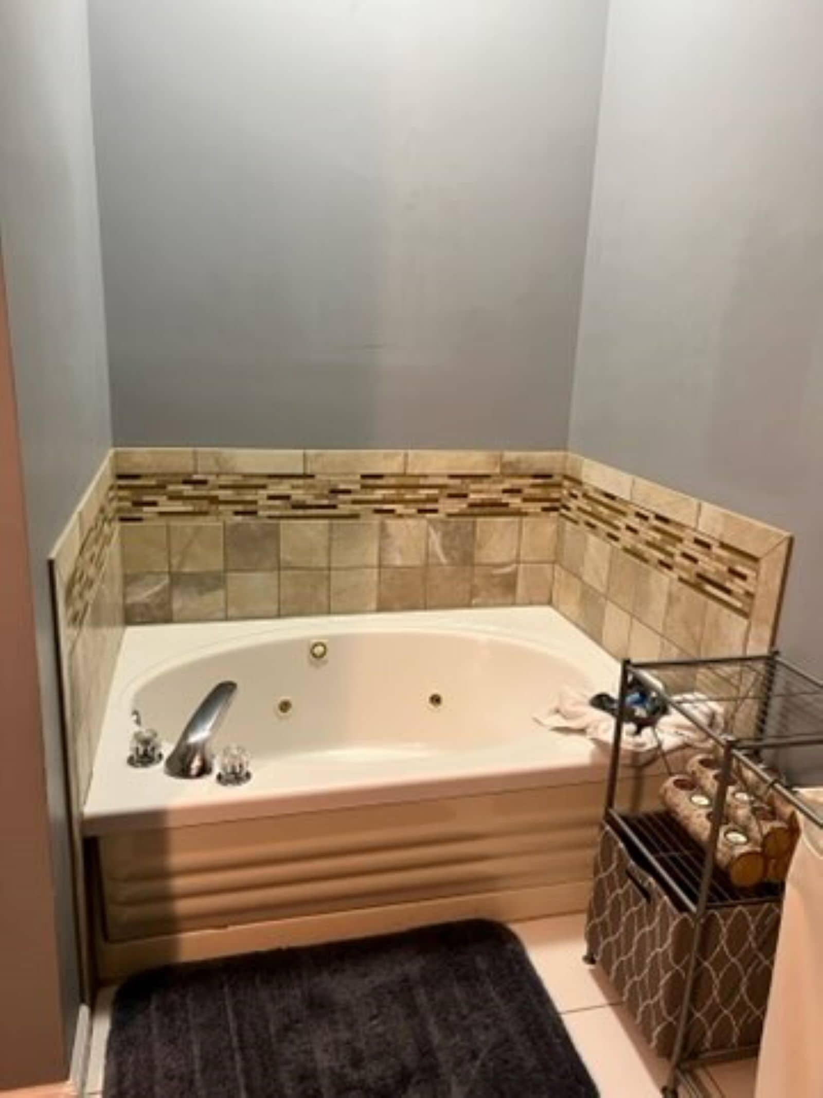 A bathroom with a freestanding bathtub, a towel rack, and a storage unit with towels.