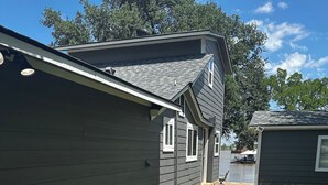 A residential property with a stone pathway leading to a house with a dark siding exterior. - Waterfront Property on PK - 7 miles away from Rocker B baseball facility  (Graford)