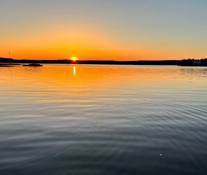 A calm body of water reflecting a sunset.